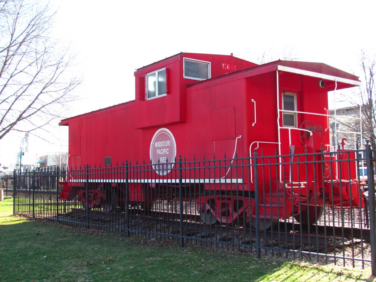The bright red caboose sits near the Chamber office for Tourism in downtown Lee's Summit, Missouri. This iconic landmark signals to visitors that they are on Third Street.