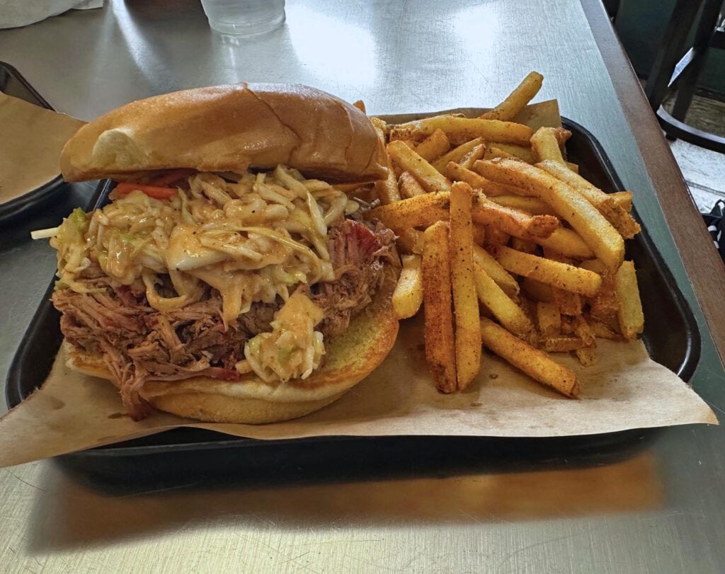 A Carolina-style pulled pork sandwich s served with fries.